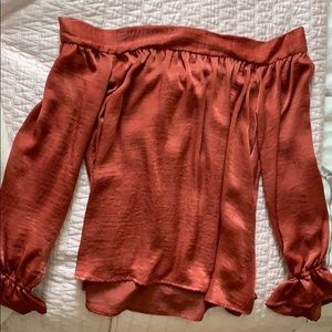 Off the shoulder burgundy/burnt orange blouse.